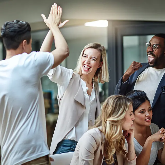 Tre personer som jubler sammen , og to som følger med på en skjerm