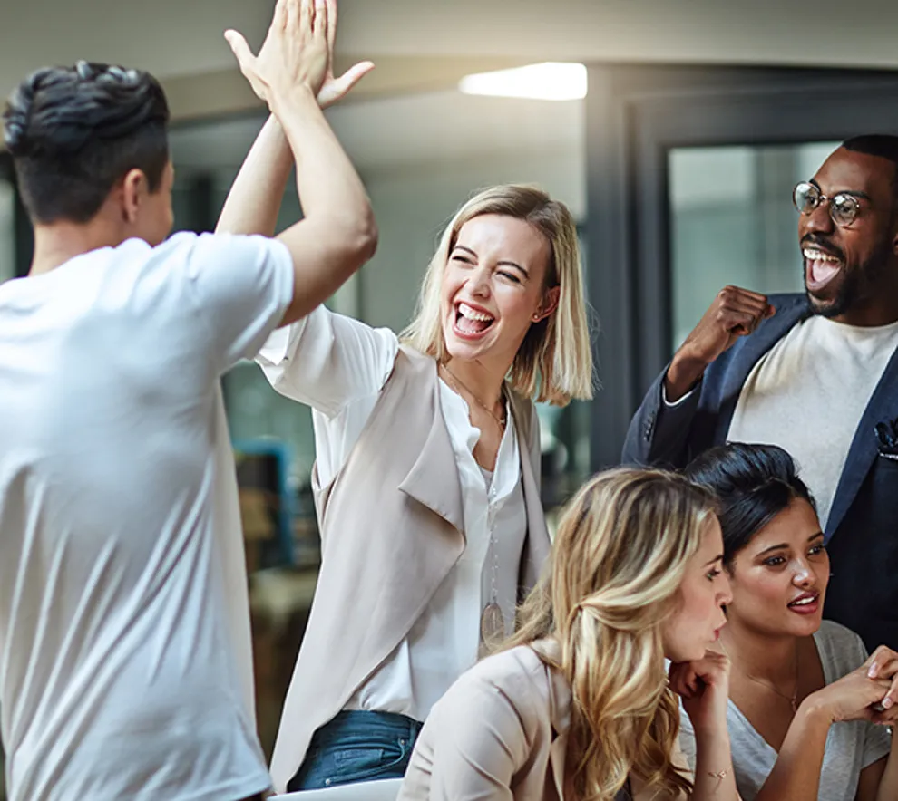 Tre personer som jubler sammen , og to som følger med på en skjerm