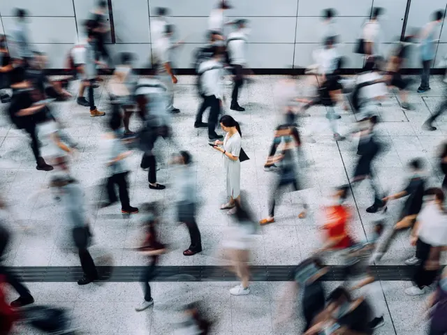 Person i folkemengde som står i ro samtidig som alle andre rundt er i bevegelse