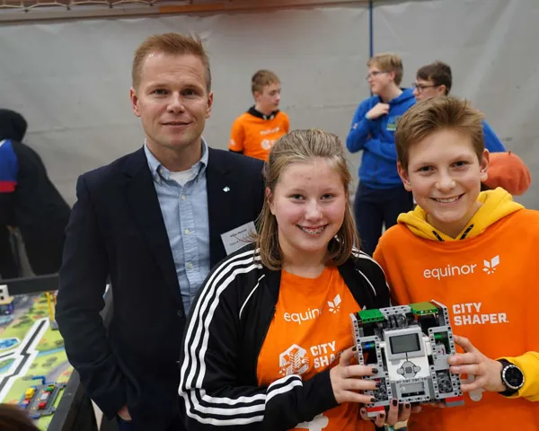 Vidar Hansen, visepresident i Tekna, står bak to barn som holder en Lego-robot