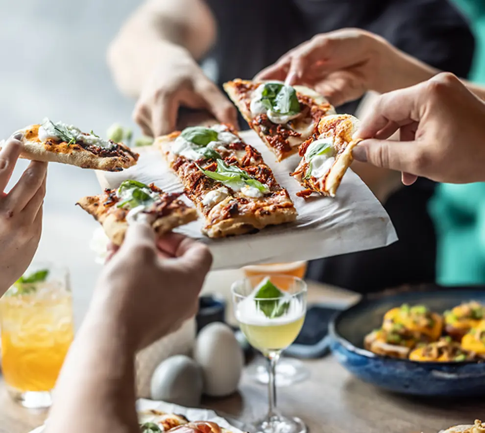 Venner som deler en pizza