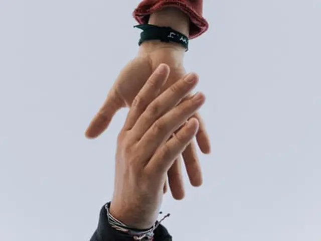 Nærbilde av en hånd som hjelper en hånd opp