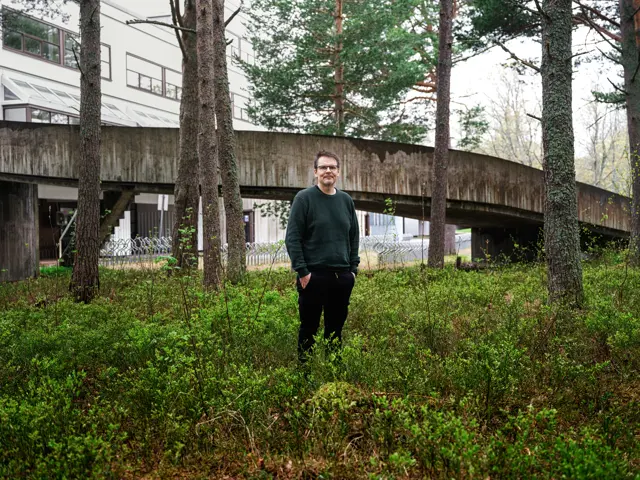 Mann som står i lyng foran en gangbro