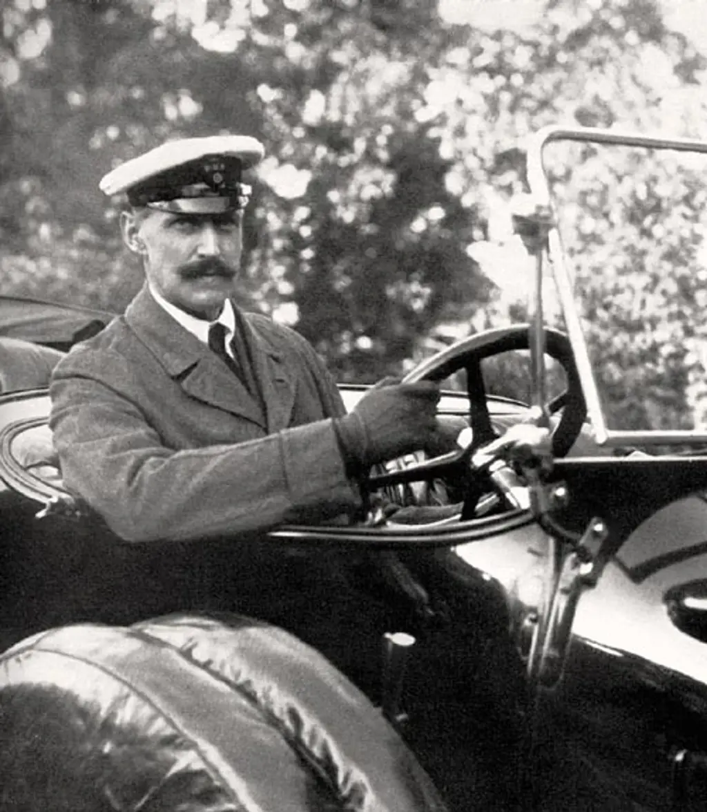 Portrettfotografi av H.M. Haakon 7 bak rattet i bil