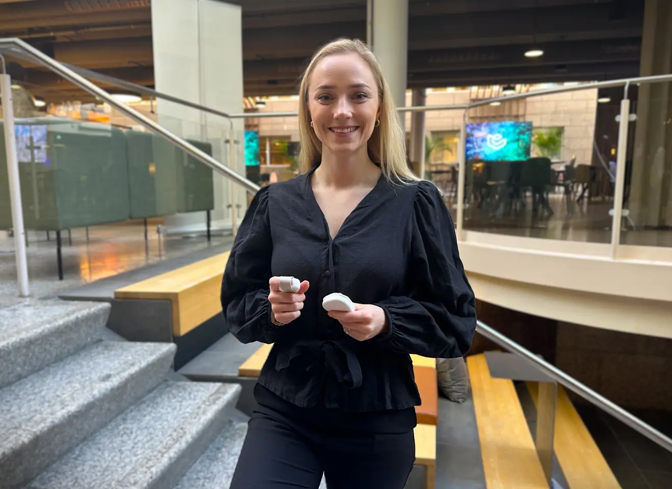 Lys blond kvinne med sorte klær i trapp