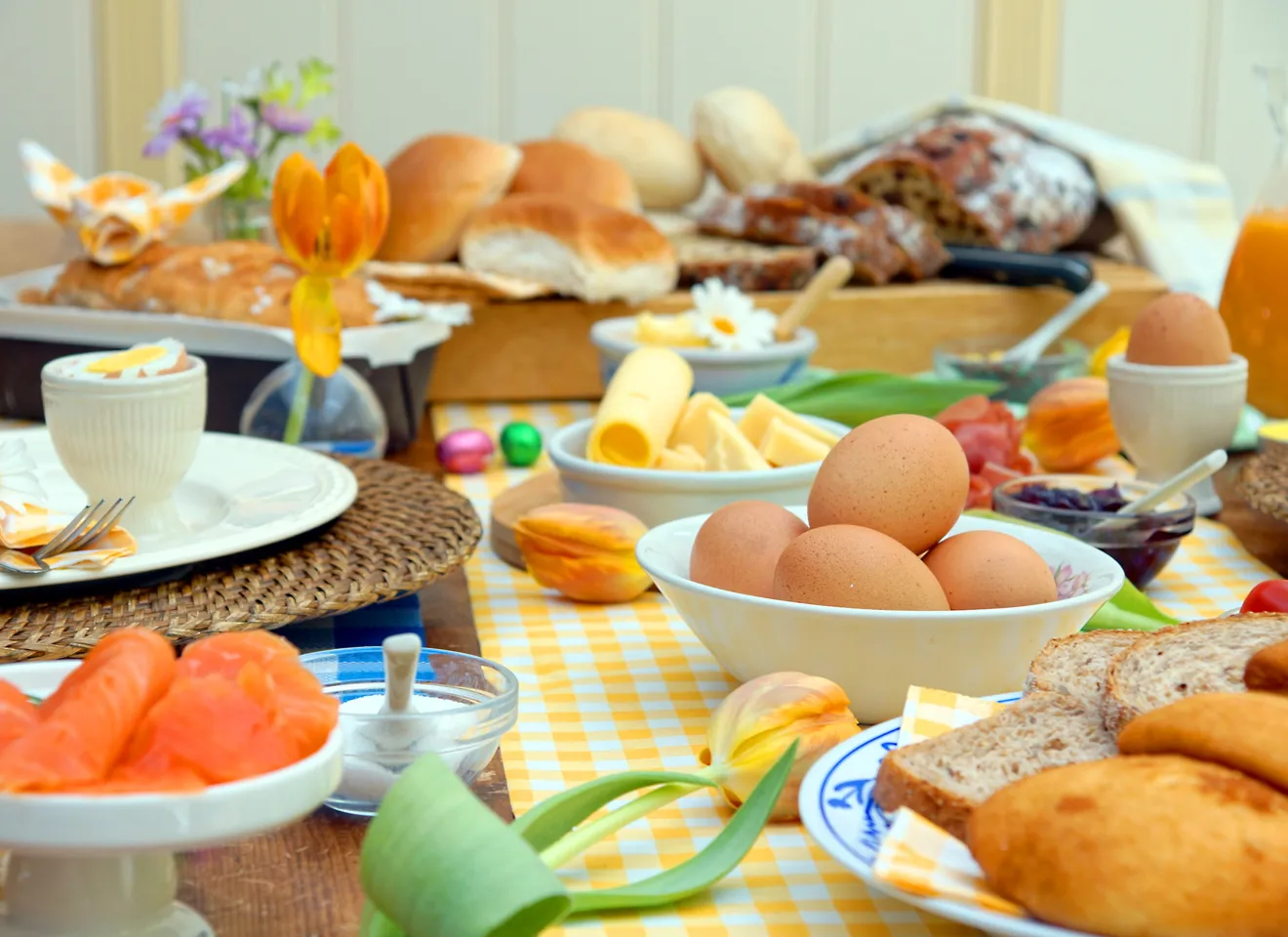 Illustrasjonsbilde av påskefrokost med egg, brød, blomster