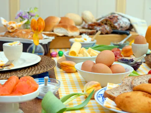 Illustrasjonsbilde av påskefrokost med egg, brød, blomster