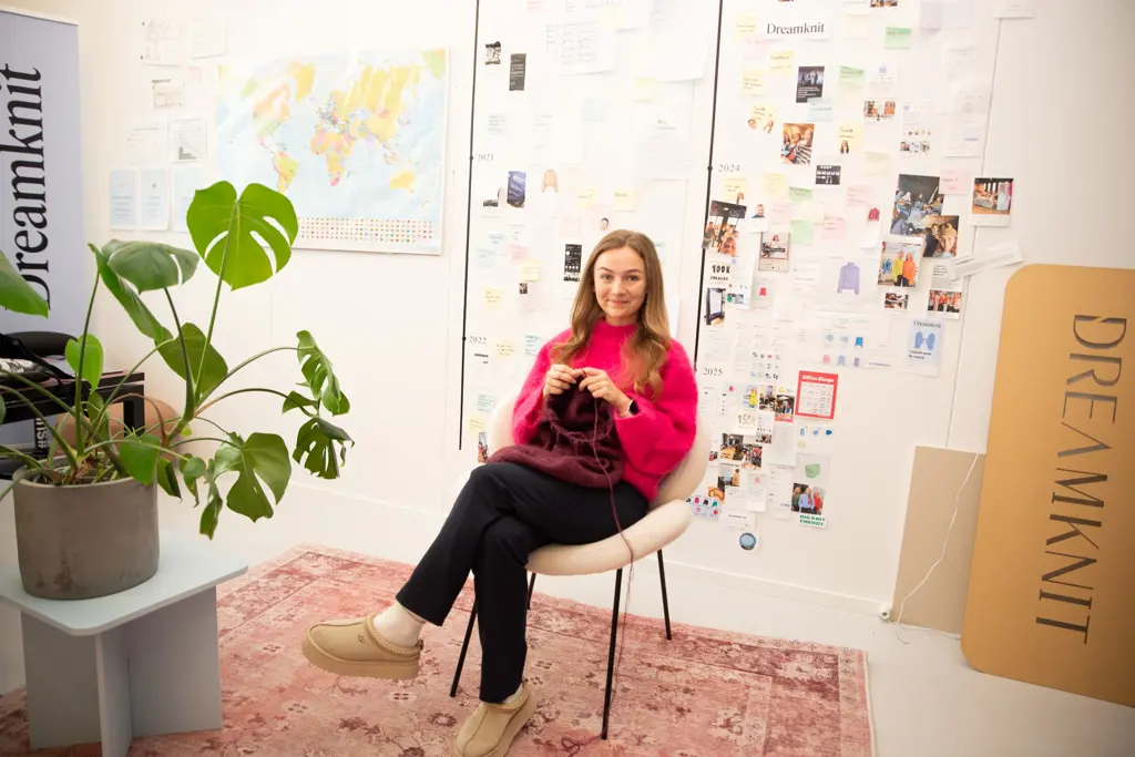 Kvinne i rosa genser sitter og strikker