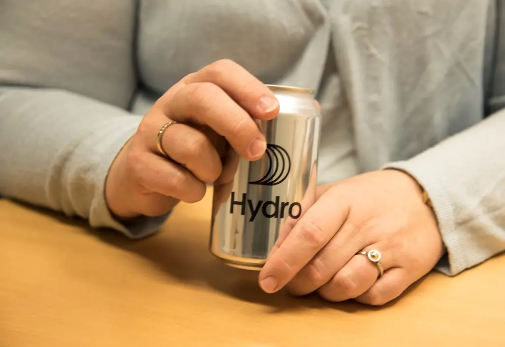 Nærbilde av hendene til  Gunn Iren Müller som holder en brusboks med Hydro-logo