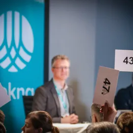 Hender som holder opp lapper med tall på