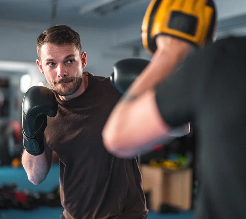 Ung mann sparrer mot treningspartner i boksing