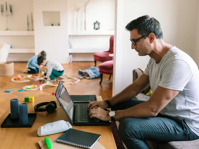 mann jobber hjemme i sofaen