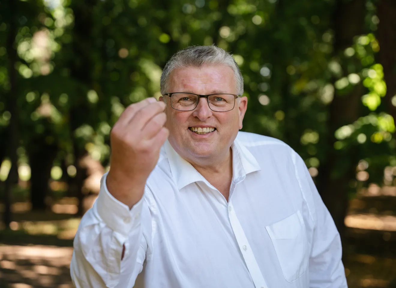 Lars Olav Grøvik i kjent positur, smilende og gestikulerende med høyre hånden