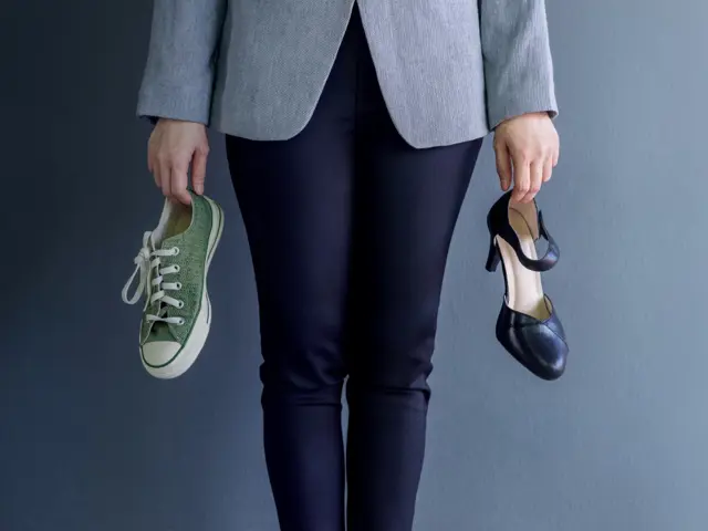 Illustrasjonbilde av en en person som holder en fritdssko i den ene hånden, og en pensko i den andre. 