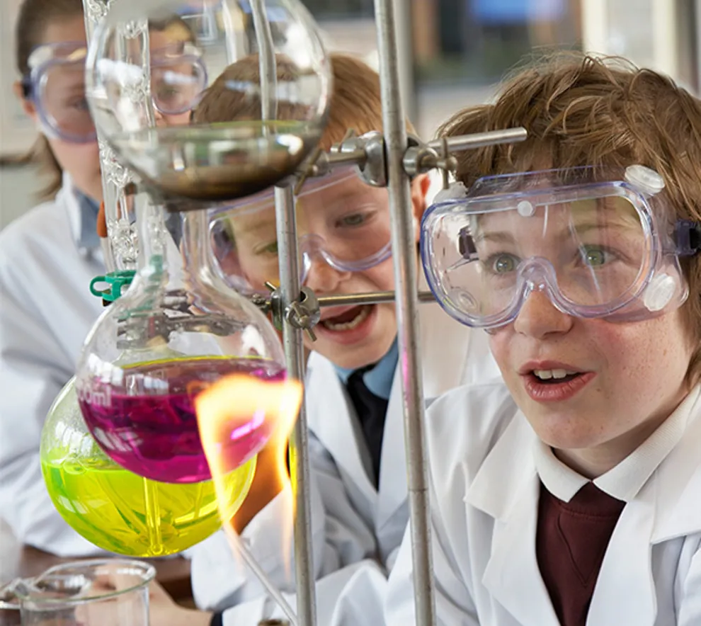 Barn som ser på en kolbe med innhold