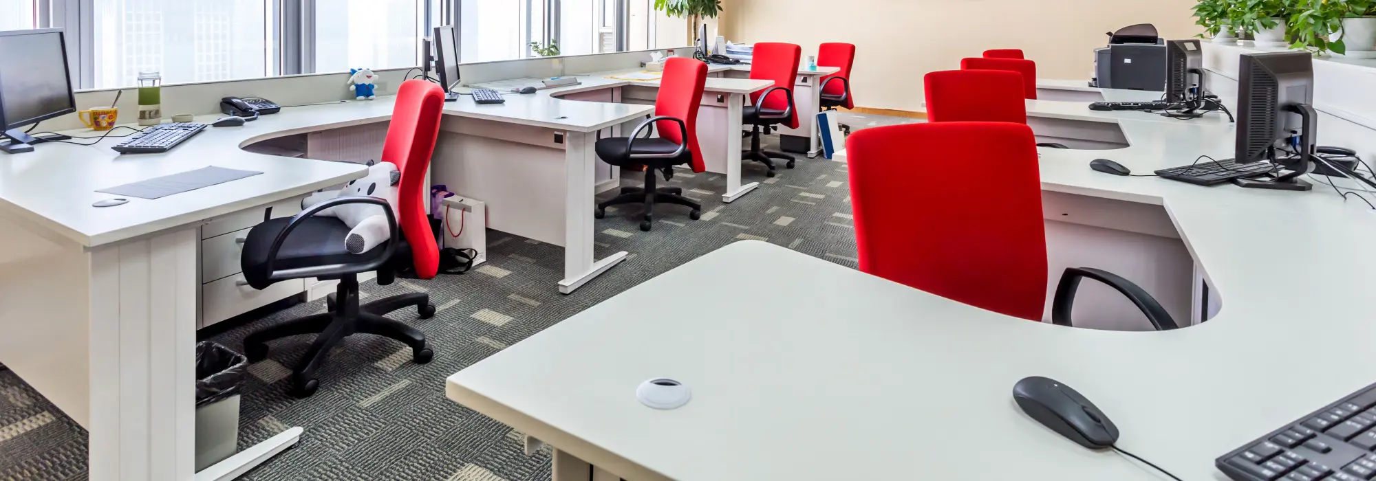 Kontorlandskap med røde, tome stoler