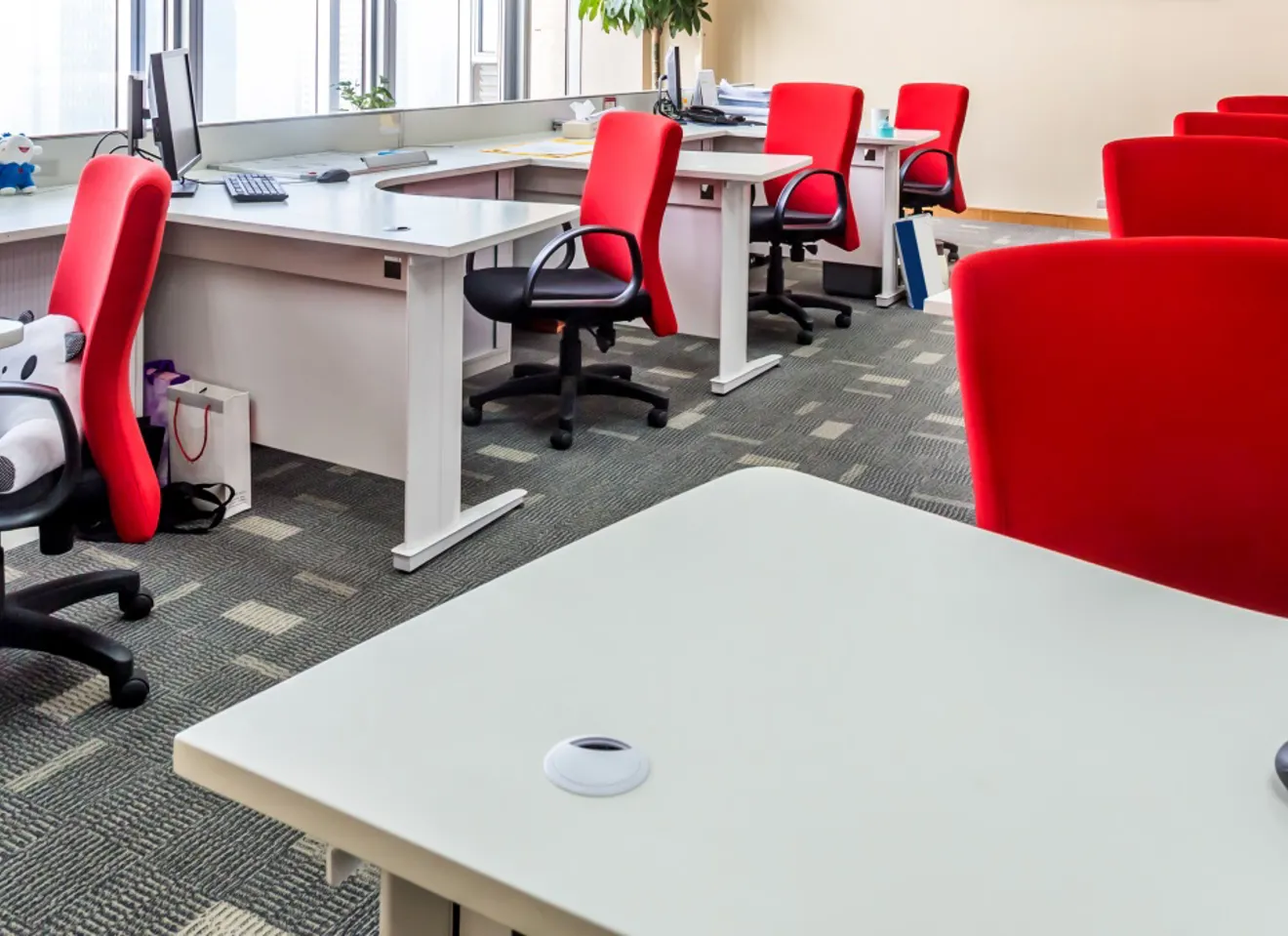 Kontorlandskap med røde, tome stoler