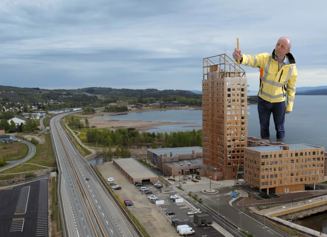 Manipulert bilde av en gigantisk Rune Abrahamsen som står ved siden av Mjøstårnet med et målebånd