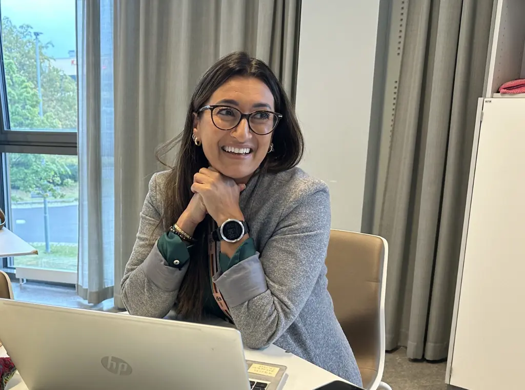 Kvinne smiler bak pc