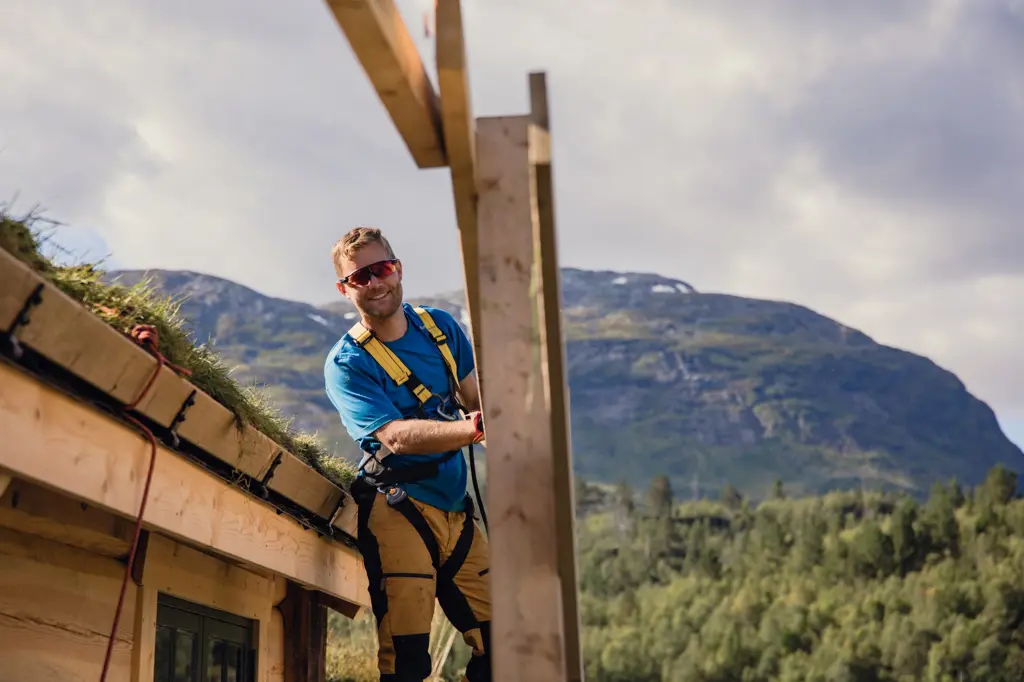 Mann snekrer foran hytte