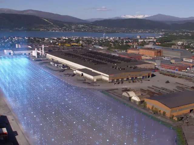 Oversiktsbilde av en fabrikk ved havet med en stor tomt ved siden av