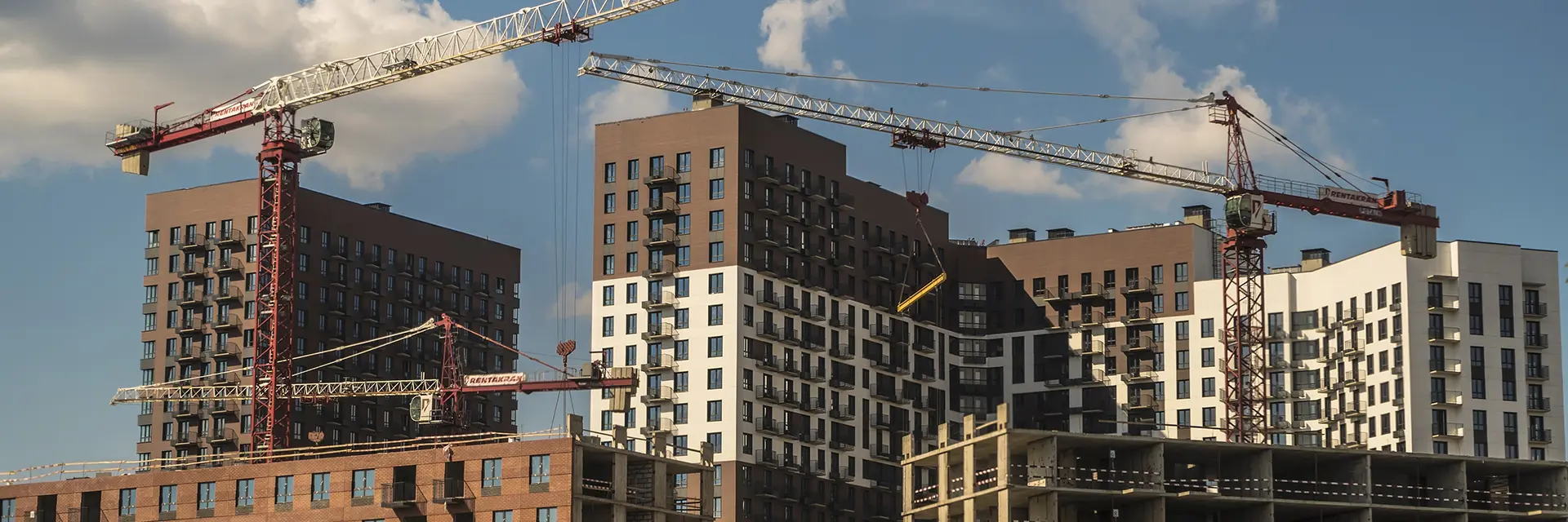 To heisekraner som holder på å bygge nye bygg