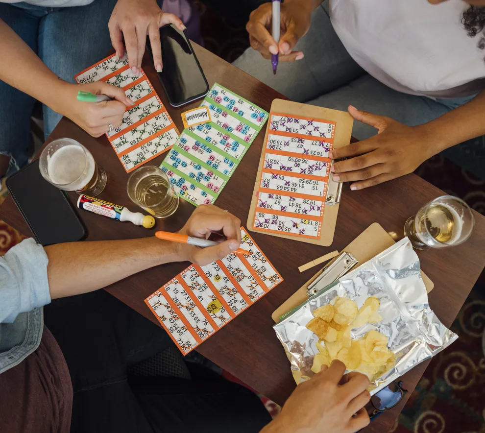 Mennesker som sitter rundt et bord og spiller bingo