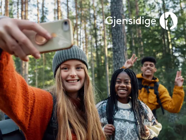 Tre unge personer i skogen ta selfie