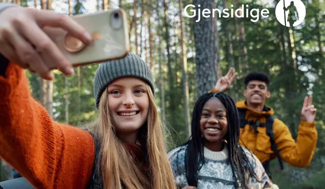 Tre unge personer i skogen ta selfie