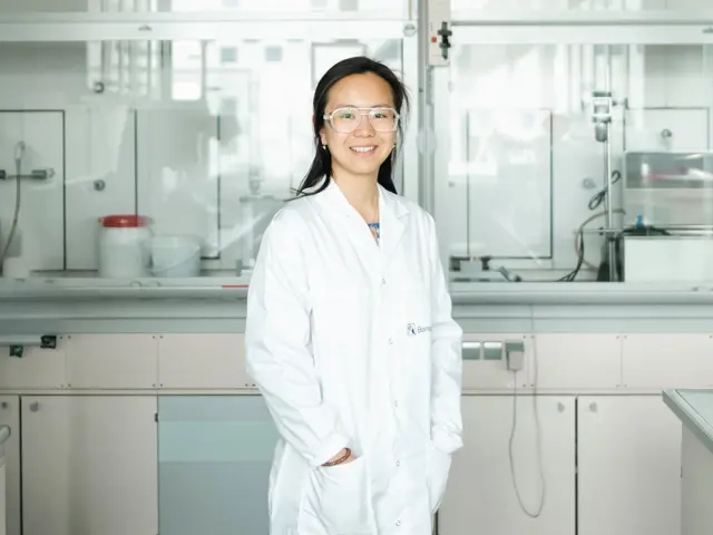 Kvinne i hvit frakk i lab