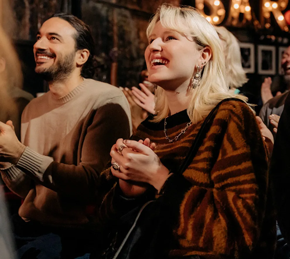 Personer i publikum som smiler