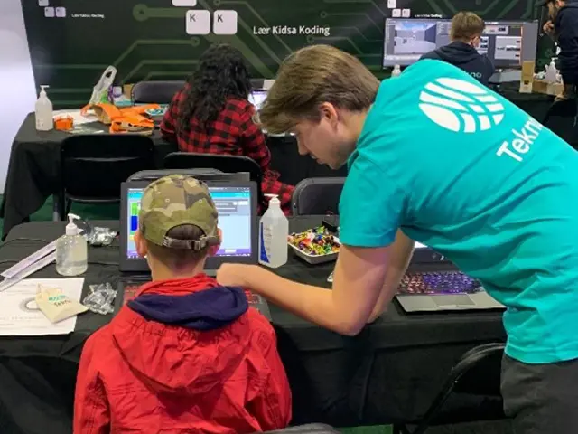 Barn sitter foran en datamaskin og koder