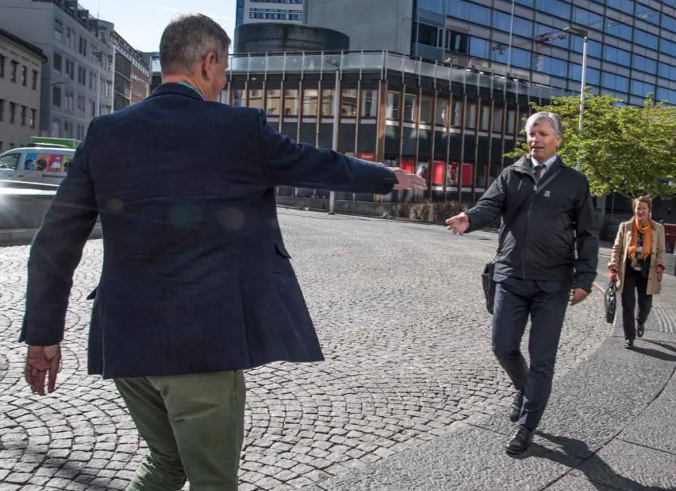 Ola Elvestuen og Tom Baade-Mathiesen hilser på hverandre på gaten utenfor Edderkoppen Teater i Oslo