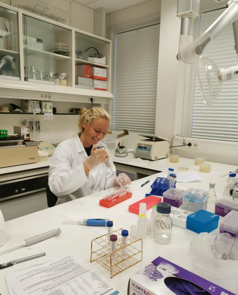 Kvinne i hvit frakk på lab