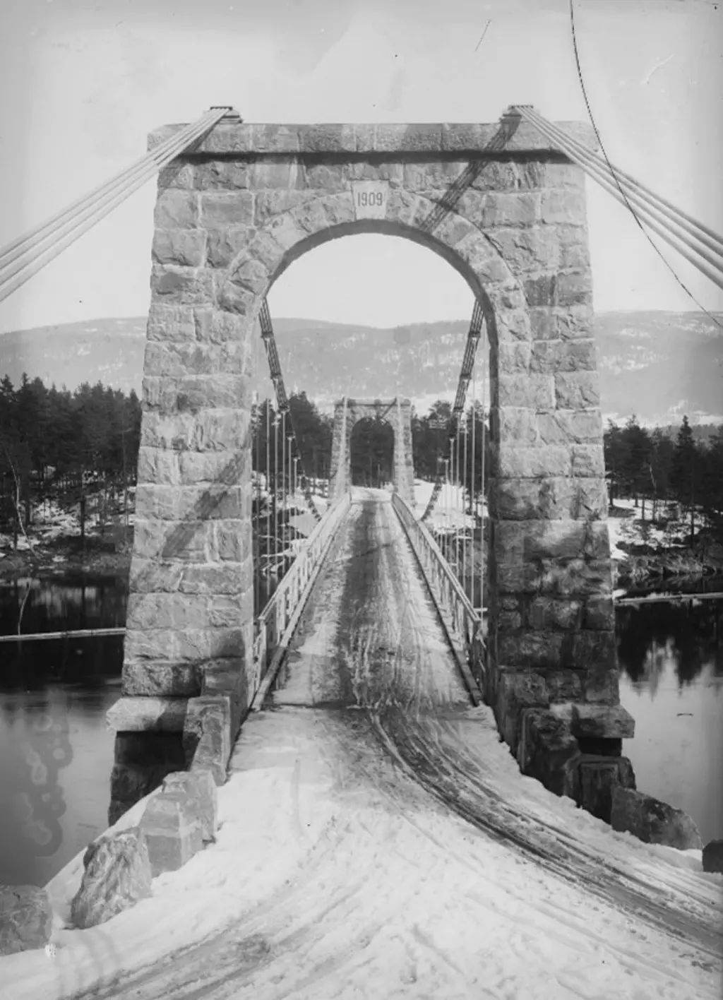 Foto i svart hvit av en bro i stein