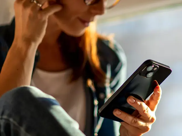 kvinne lytter til sin mobil