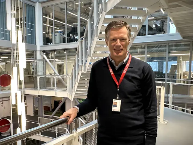 mann ved rekkverk i atrium 