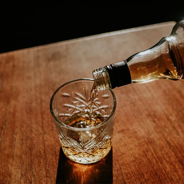 Flaske med akevitt som helles i et glass