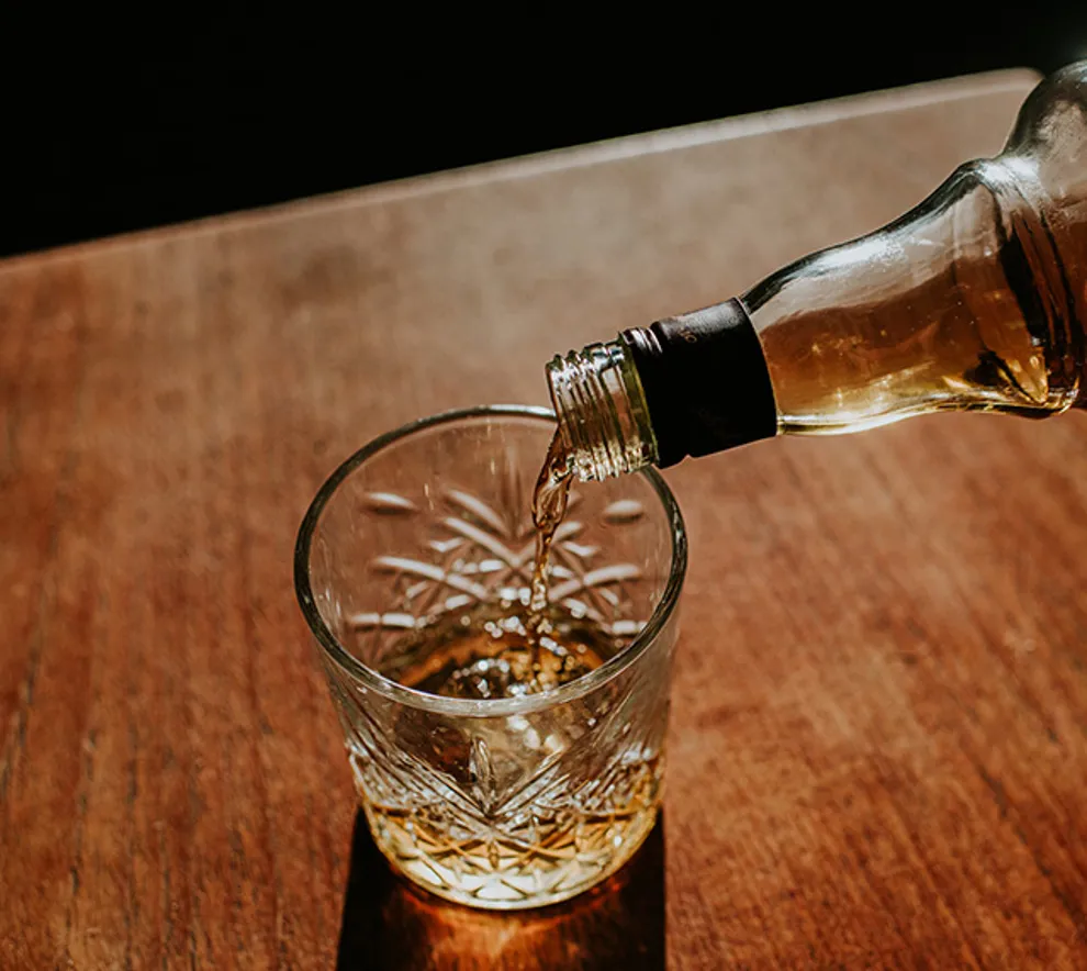 Flaske med akevitt som helles i et glass