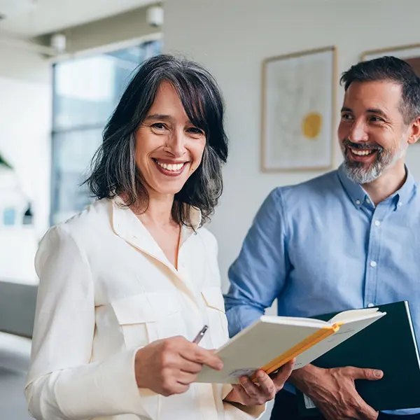 Kvinne og mann som smiler på jobb