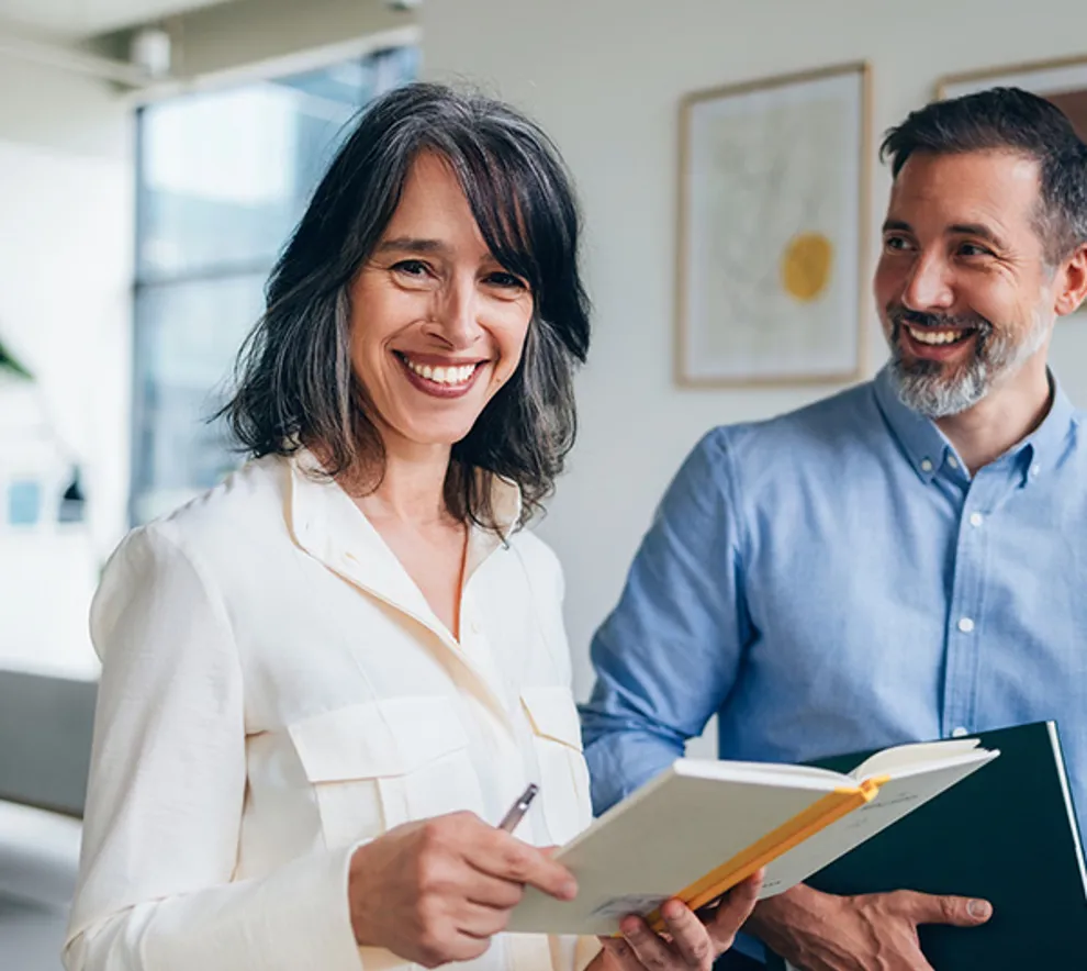 Kvinne og mann som smiler på jobb