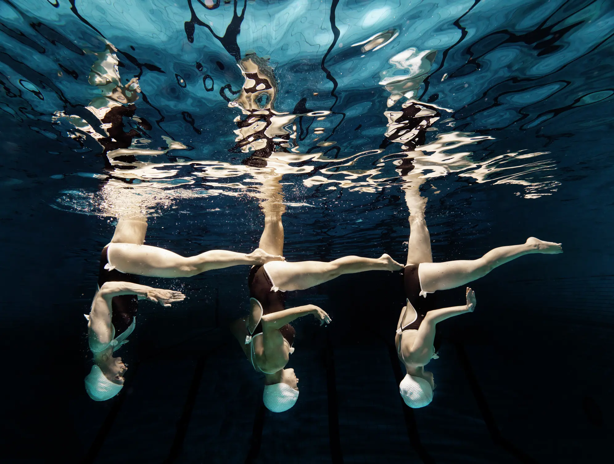 Illustrasjonsbilde av 3 kvinner som danser vannballett i et svømmebasseng
