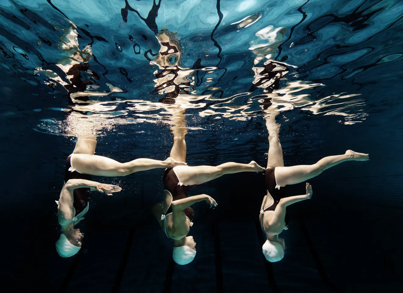 Illustrasjonsbilde av 3 kvinner som danser vannballett i et svømmebasseng