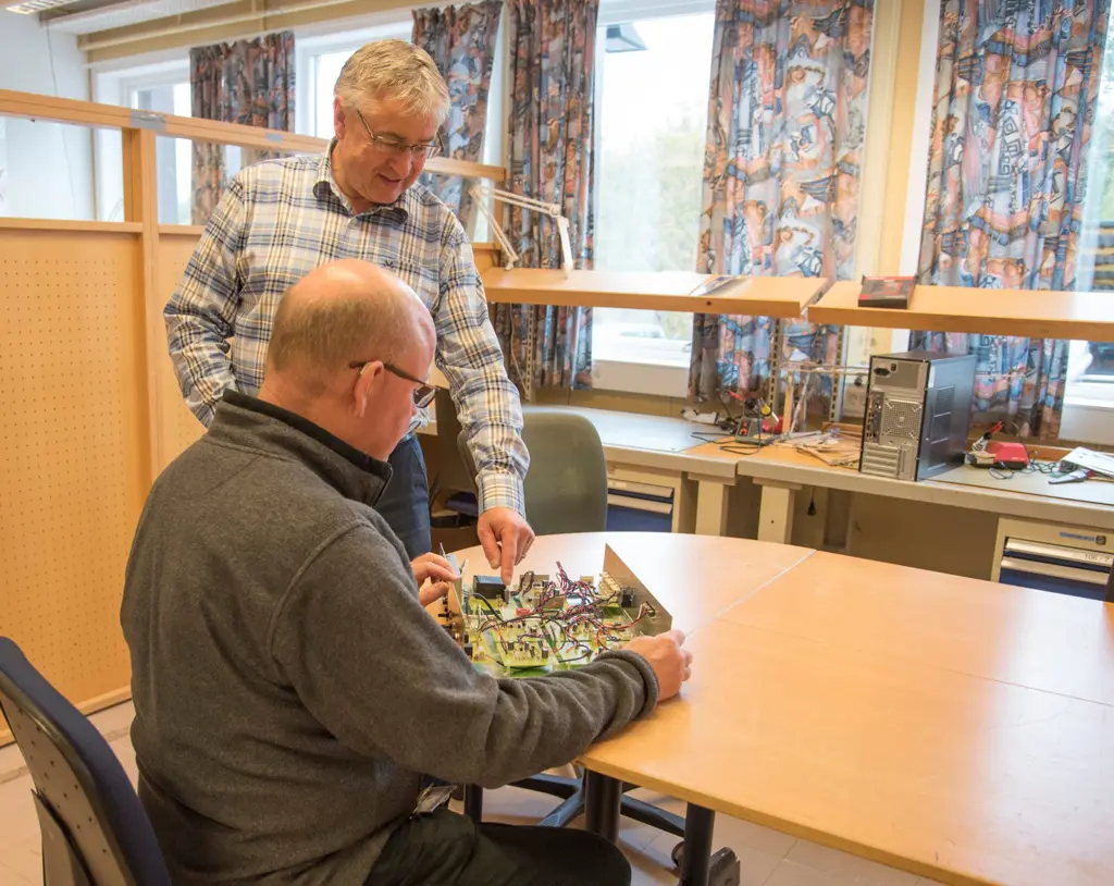 Leif Erik Haugstad og en person ved et bord jobber med et kretskort