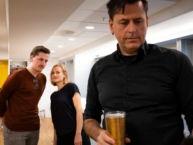 To kollegaer skuler over på en annen kollega. 