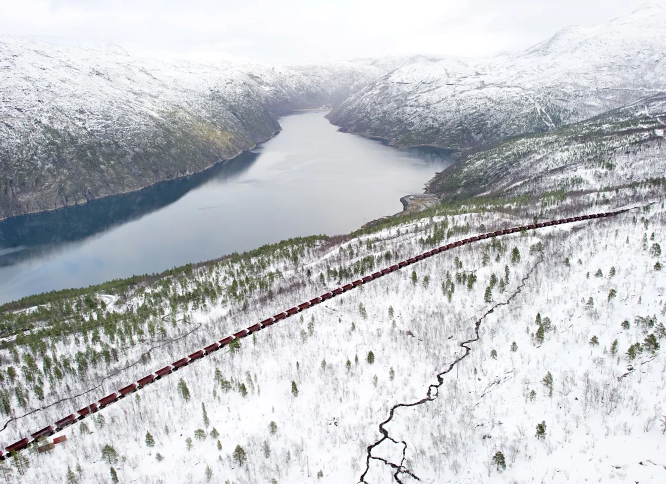 Panoramabilde av et landskap hvor et langt tog med jernmalm kjører