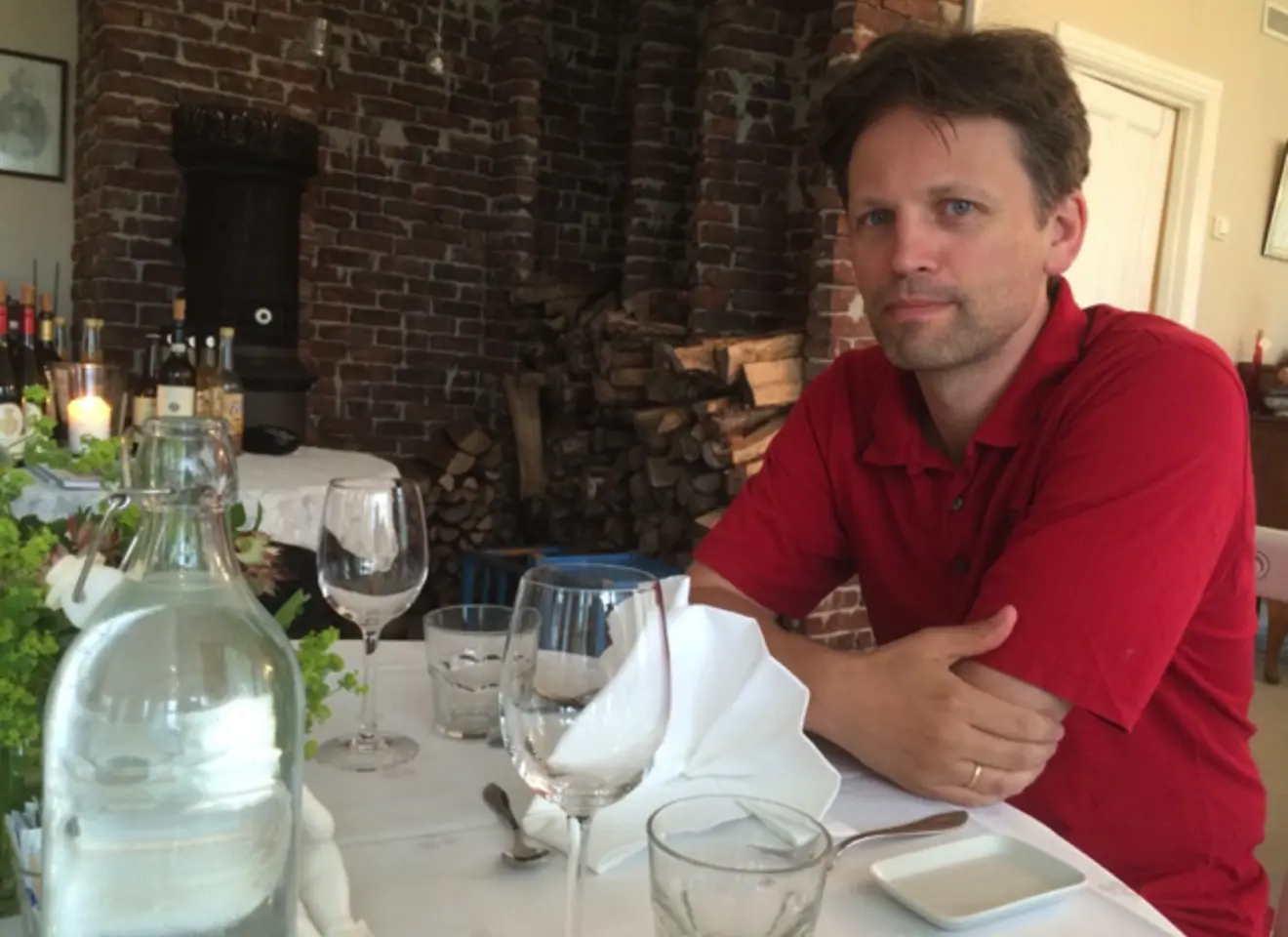 Øystein Vandvik sitter ved middagsbordet i et restaurant og smiler til kamera