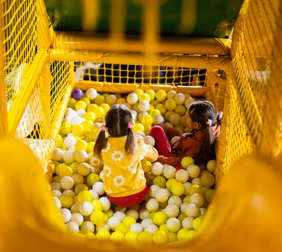To jenter som leker i en ballbinge