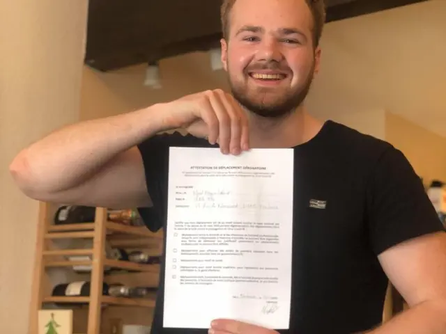 En ung mann som viser frem et papirark 