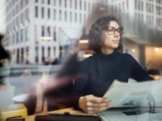 mellomfornøyd kvinne leser avisen